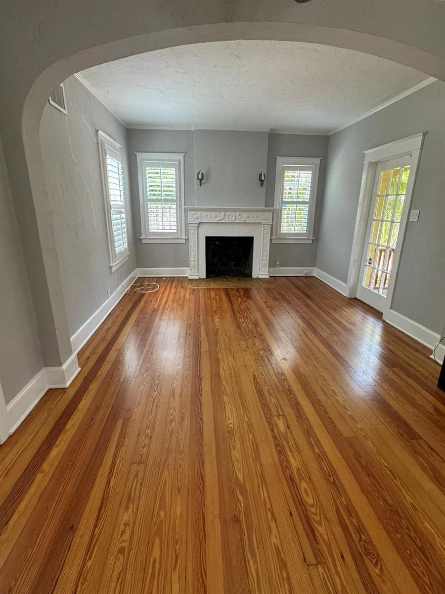 A living room with hardwood floors, a fireplace, two windows, and an arched entryway — 226 NE 7th, Delray Beach FL 33483, DELRAY BEACH, FL