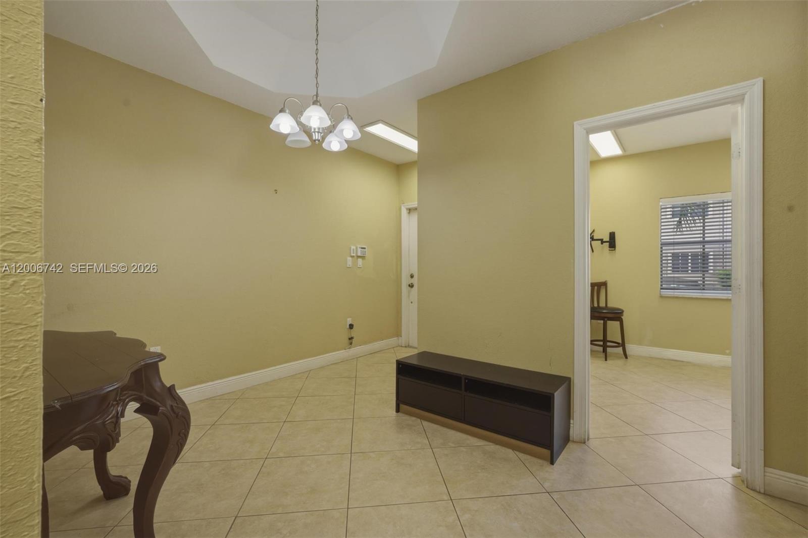 An interior room features tile flooring, a chandelier, and an open doorway to another space — 16613 NW 71st Ave, Miami Lakes FL 33014, MIAMI LAKES, FL