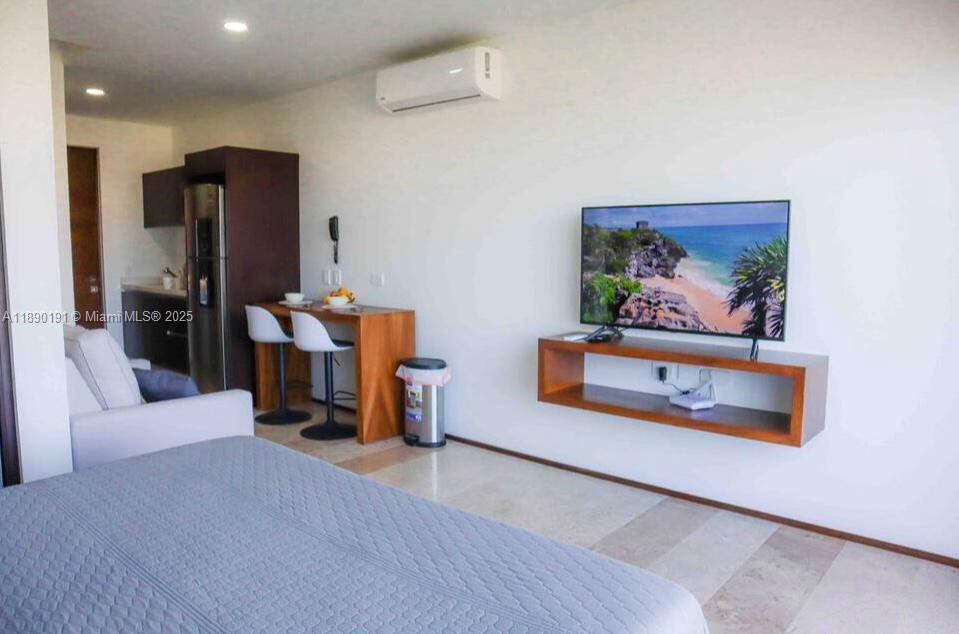 A bedroom features a bed, a wall-mounted television, a small dining area, and a kitchenette — Menesse Tulum C. Asteroide, Tulum Centro # 329, QR, QR