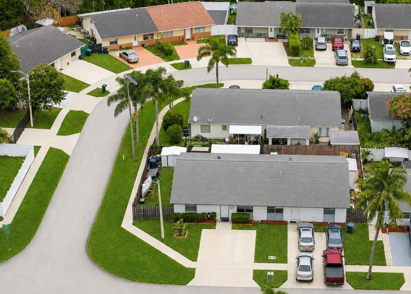 An aerial view shows a residential neighborhood with single-story homes, driveways, and parked cars — 4908 PIMLICO COURT, WEST PALM BEACH, FL