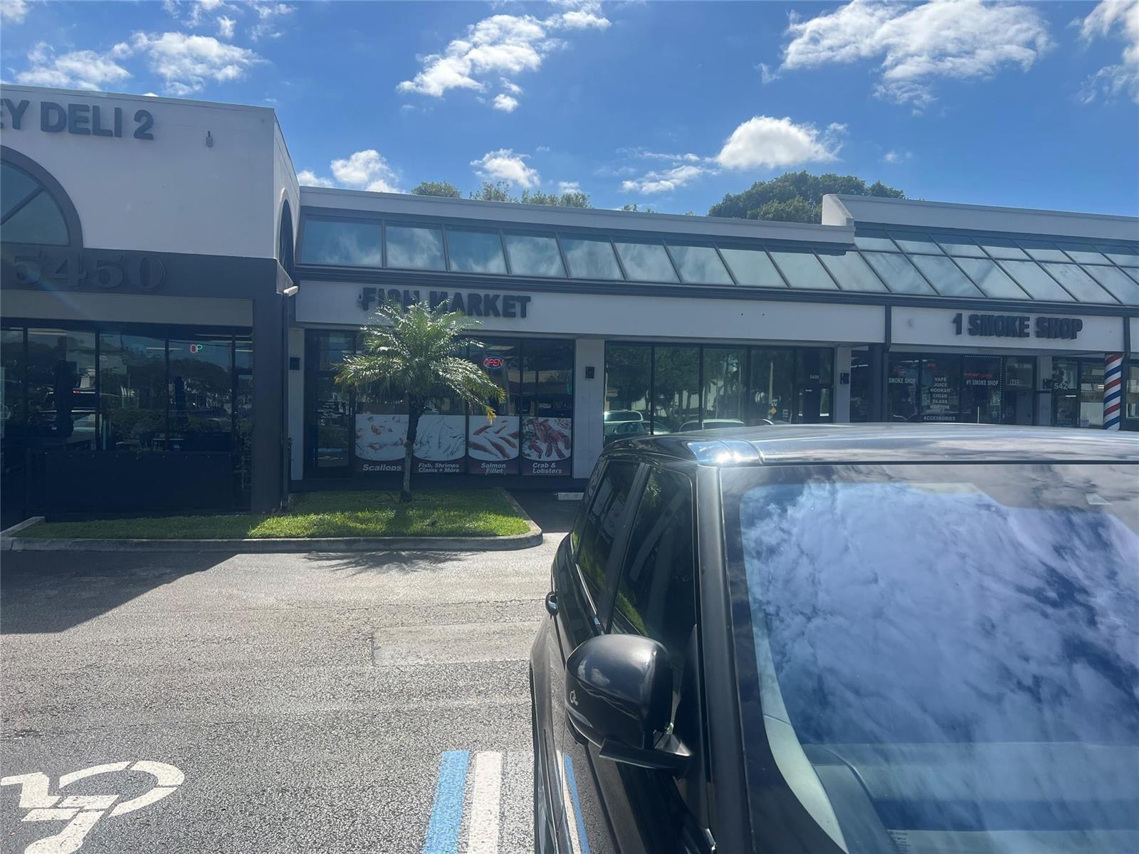 A fish market and smoke shop storefronts in a strip mall with a parking lot — 5418 W Atlantic Boulevard, Margate FL 33063, MARGATE, FL