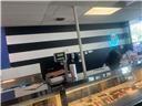 A service counter with a glass display case sits before a black and white striped wall — 5418 W Atlantic Boulevard, Margate FL 33063, MARGATE, FL