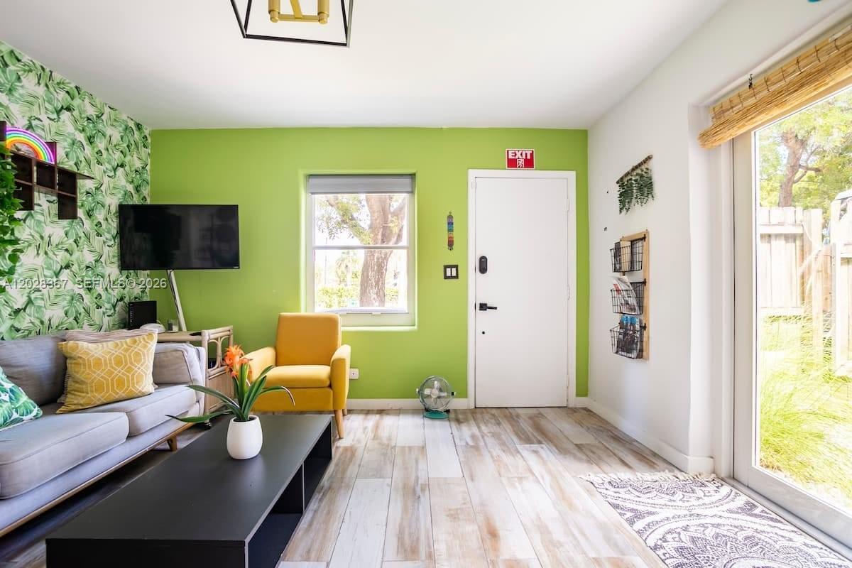 A living room features green walls, a gray sofa, a yellow chair, and wood-look flooring — 1516 S 17th Ave # 1516, Hollywood FL 33020, HOLLYWOOD, FL