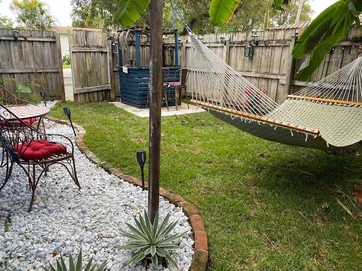 A backyard features a hammock, a gravel patio area with metal chairs, and a wooden fence — 1516 S 17th Ave # 1516, Hollywood FL 33020, HOLLYWOOD, FL