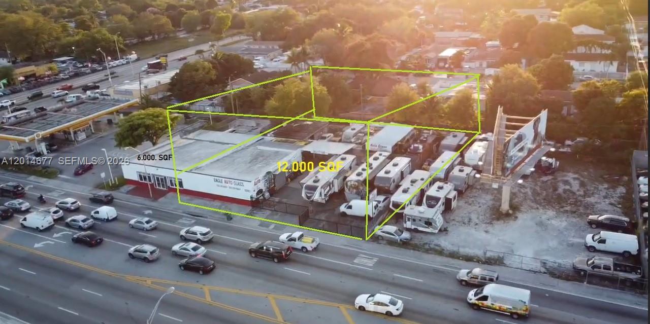 An aerial view shows a commercial building with an adjacent lot filled with parked vehicles — 10400 SW 27th St, Miami FL 33165, MIAMI, FL
