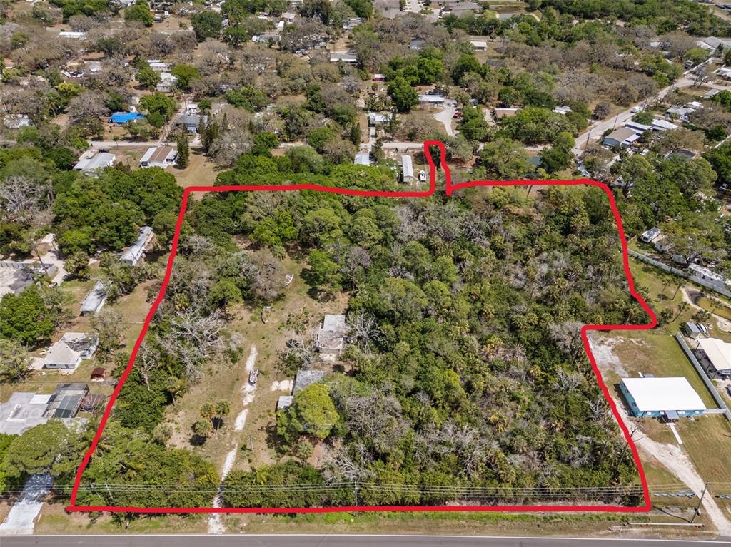 An aerial view shows a large, wooded residential lot outlined in red — 1204 BAILLIES BLUFF ROAD, HOLIDAY, FL