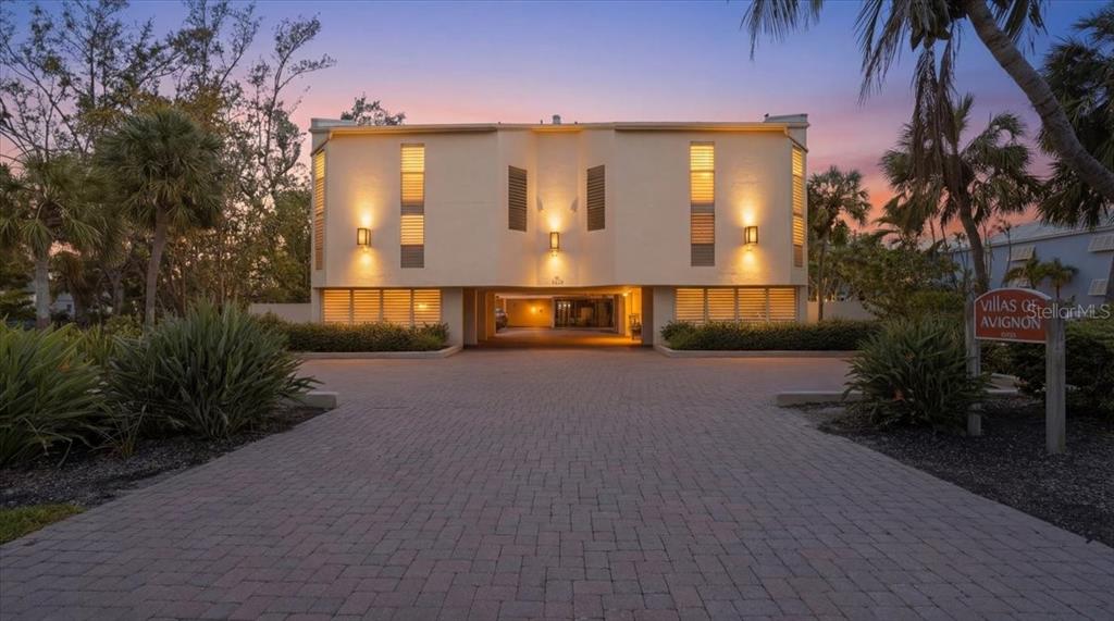 A two-story apartment building with a paved driveway and a sign for Villas of Avignon — 5611 GULF OF MEXICO DRIVE UNIT 3, LONGBOAT KEY, FL