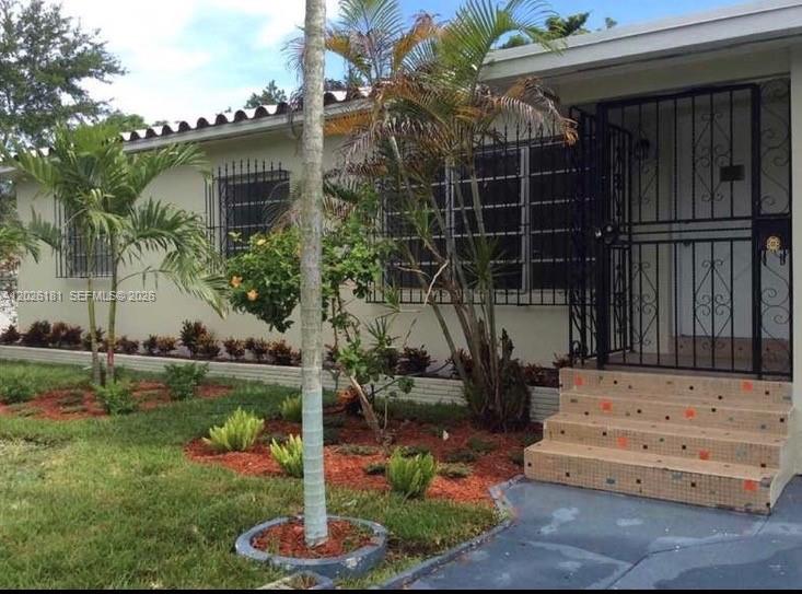 The exterior of a single-story house features a front porch with steps and security bars — 730 NE 139 ST, North Miami FL 33161, NORTH MIAMI, FL