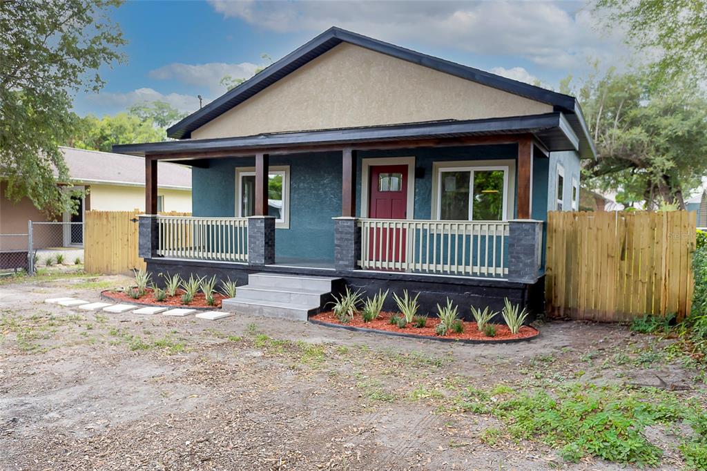 A blue house with a covered front porch, stone pillars, and a red front door — 3203 E EMMA STREET, TAMPA, FL