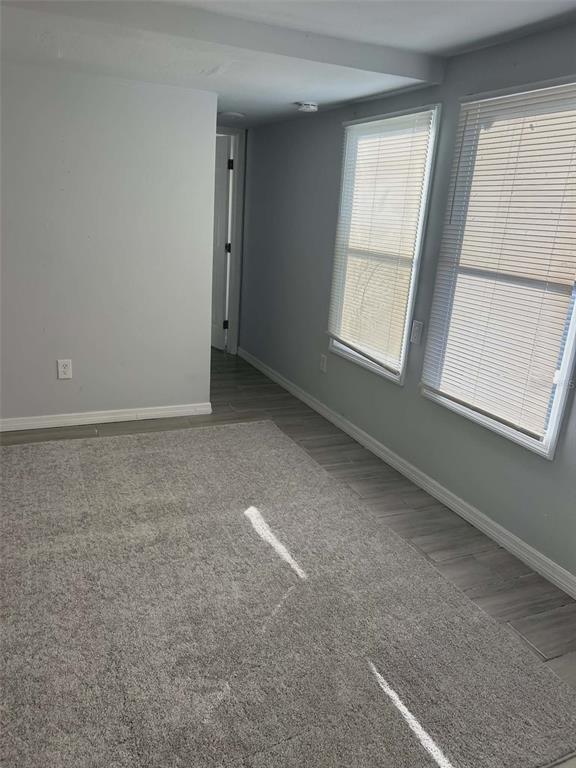 A room with gray walls, gray wood-look flooring, a gray area rug, and two windows — 1106 50TH AVENUE DRIVE W, BRADENTON, FL