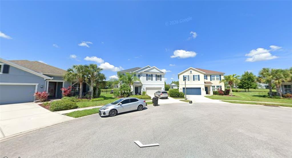 A street view shows three suburban houses with driveways and parked cars under a blue sky — 2672 VERONA LANE, ODESSA, FL