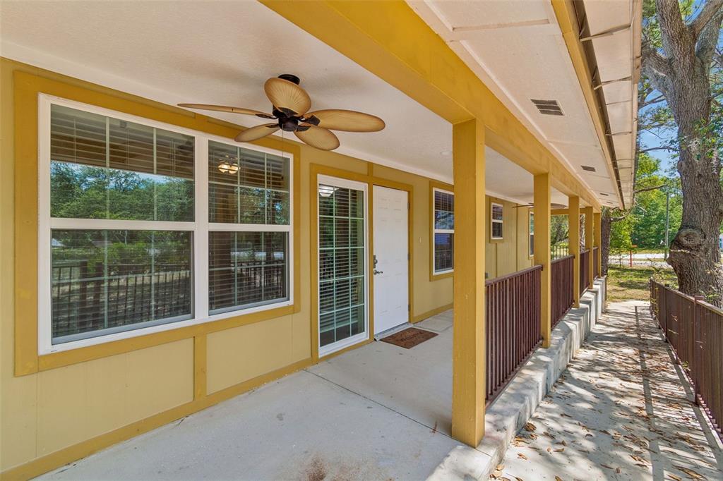 A covered porch with yellow siding, a ceiling fan, and a metal railing — 11274 S RIVIERA DRIVE, HOMOSASSA, FL