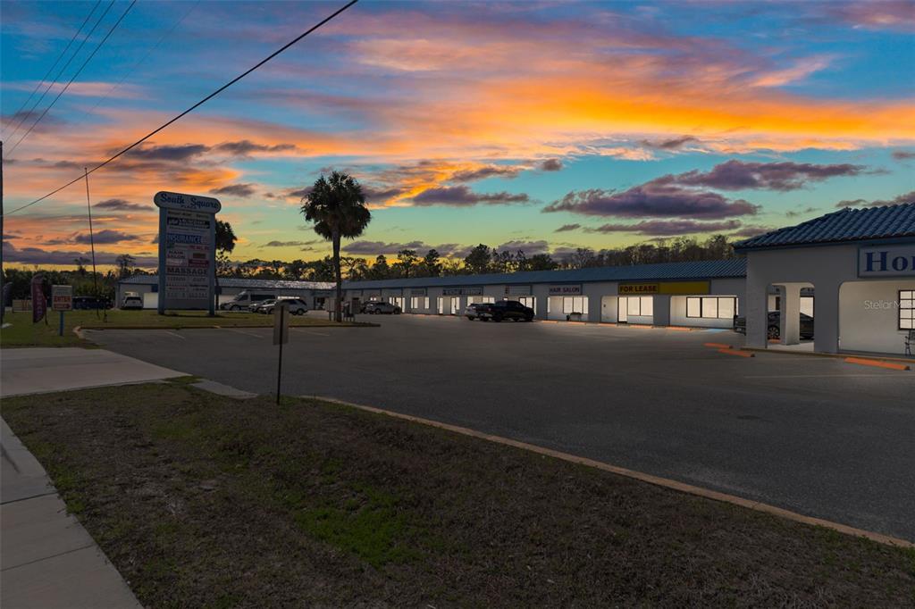 A strip mall with a large parking lot under a colorful sunset sky — 940 N SUNCOAST BOULEVARD, CRYSTAL RIVER, FL