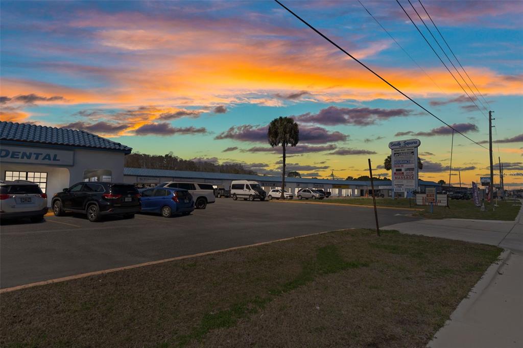 A parking lot in front of a strip mall under a colorful sunset sky — 940 N SUNCOAST BOULEVARD, CRYSTAL RIVER, FL