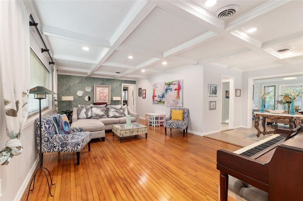 A living room features a coffered ceiling, hardwood floors, and a blue accent wall — 1210 SE 14TH AVENUE, OCALA, FL