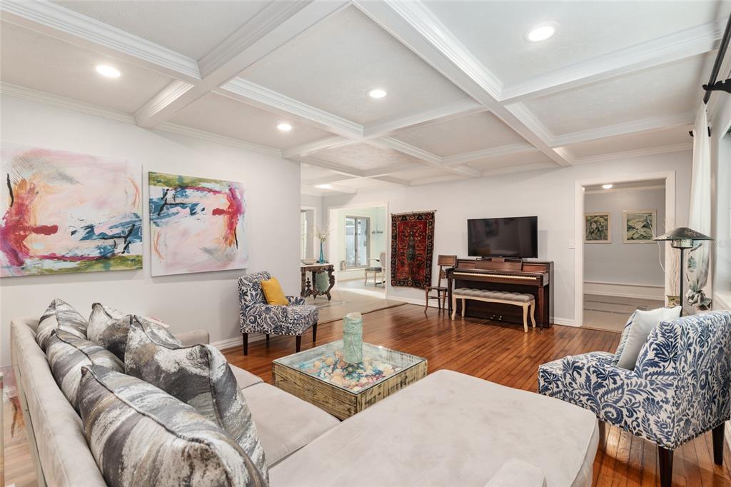 A living room features a coffered ceiling, hardwood floors, a sectional sofa, and a piano — 1210 SE 14TH AVENUE, OCALA, FL