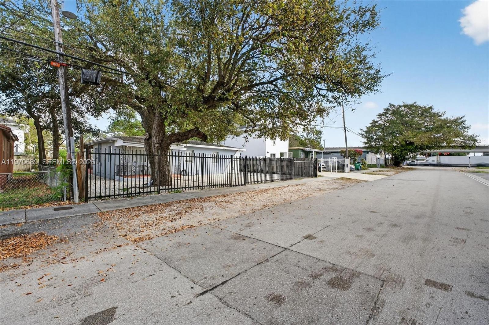 A street view shows a fenced-in single-story house shaded by a large tree — 2741 NW 43rd Ter, Miami FL 33142, MIAMI, FL