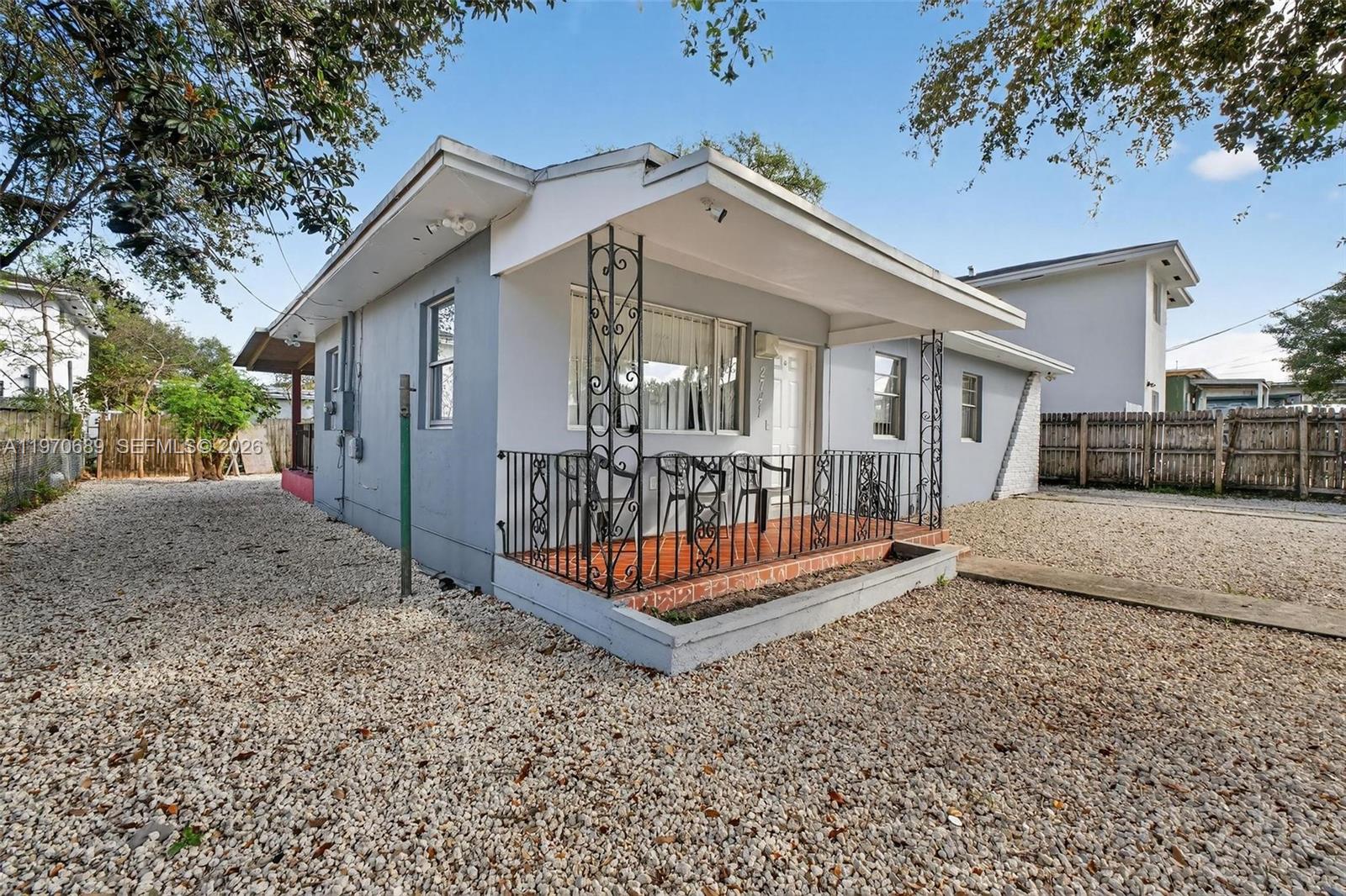 A light gray single-story house features a front porch with decorative iron railings and columns — 2741 NW 43rd Ter, Miami FL 33142, MIAMI, FL
