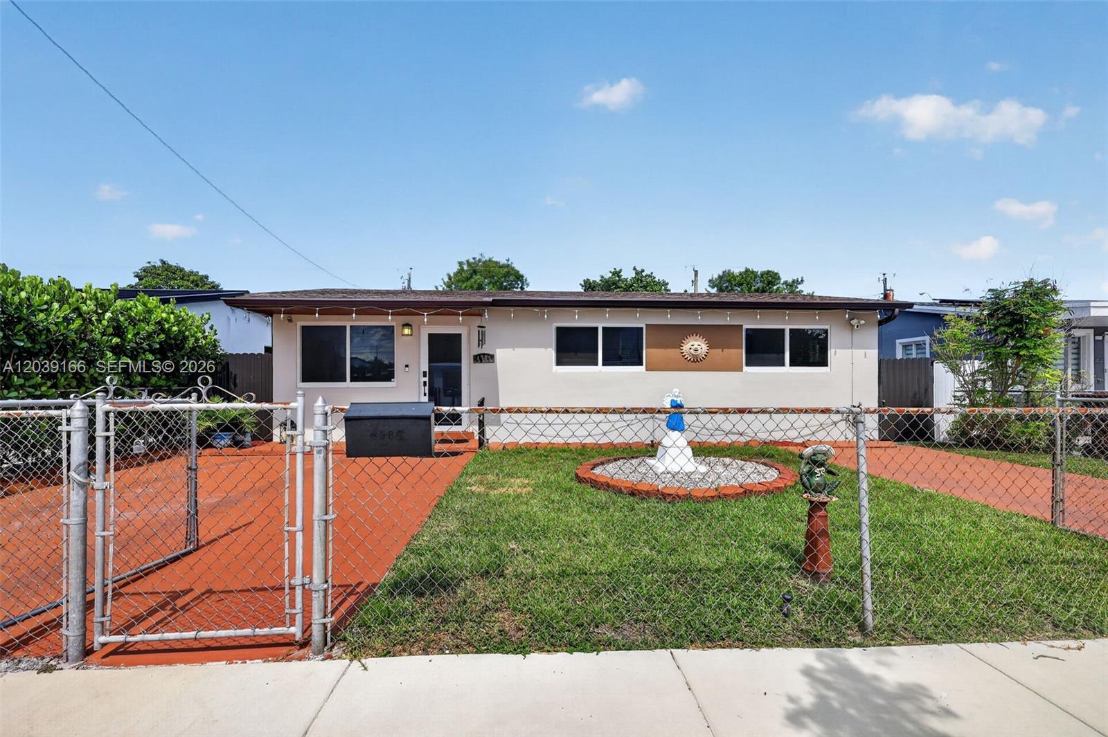 A single-story house with a chain-link fence, a front lawn, and a paved driveway — 4585 E 9th Ln, Hialeah FL 33013, HIALEAH, FL