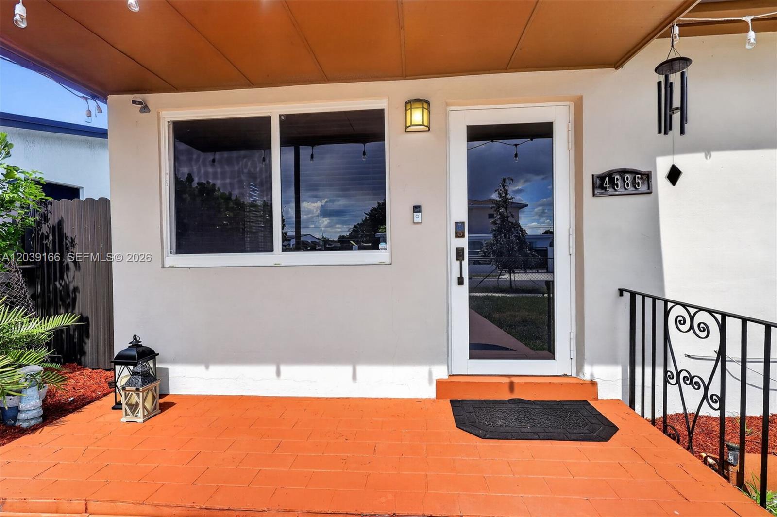 The exterior view shows a front porch with orange tiles, a window, and a door — 4585 E 9th Ln, Hialeah FL 33013, HIALEAH, FL