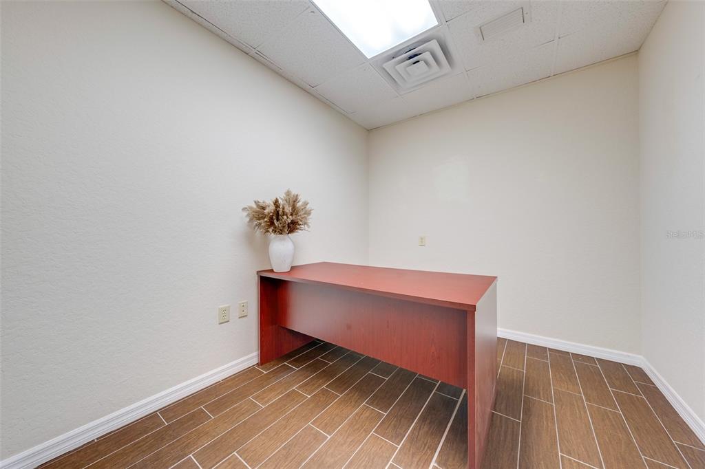 A small office features a wooden desk, a vase with dried flowers, and tile flooring — 917 EMMETT STREET, KISSIMMEE, FL
