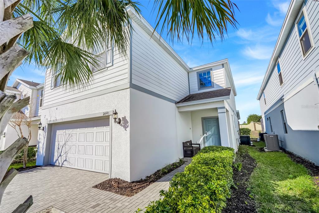 A two-story house with white siding, a two-car garage, and a paved driveway — 2440 TANGIER DRIVE, KISSIMMEE, FL