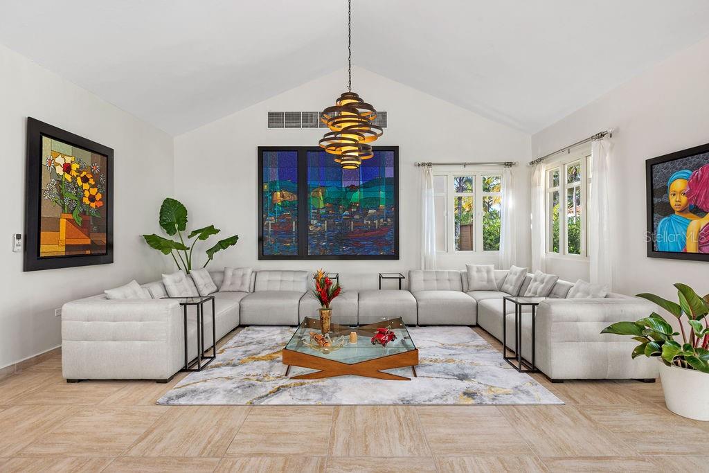 A living room features a large sectional sofa, a glass coffee table, and colorful wall art — 251 DORADO BEACH EAST, DORADO, PR