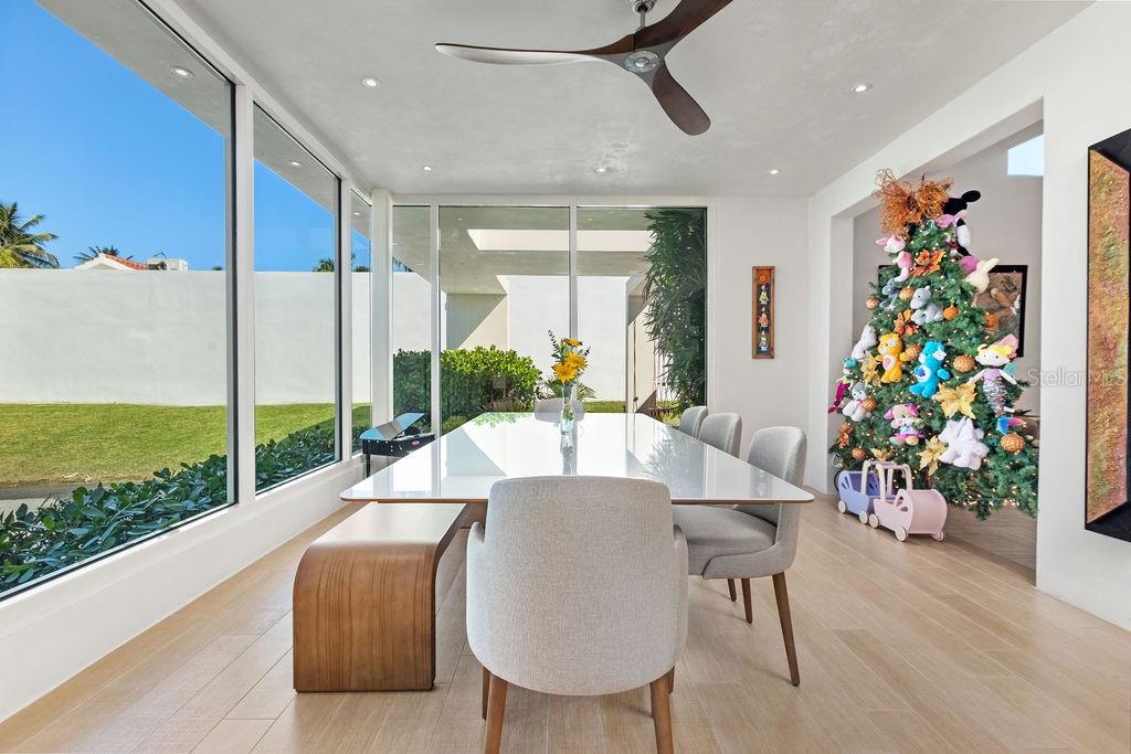 A dining room features a white table, light-colored chairs, a wooden bench, and a Christmas tree — 251 DORADO BEACH EAST, DORADO, PR