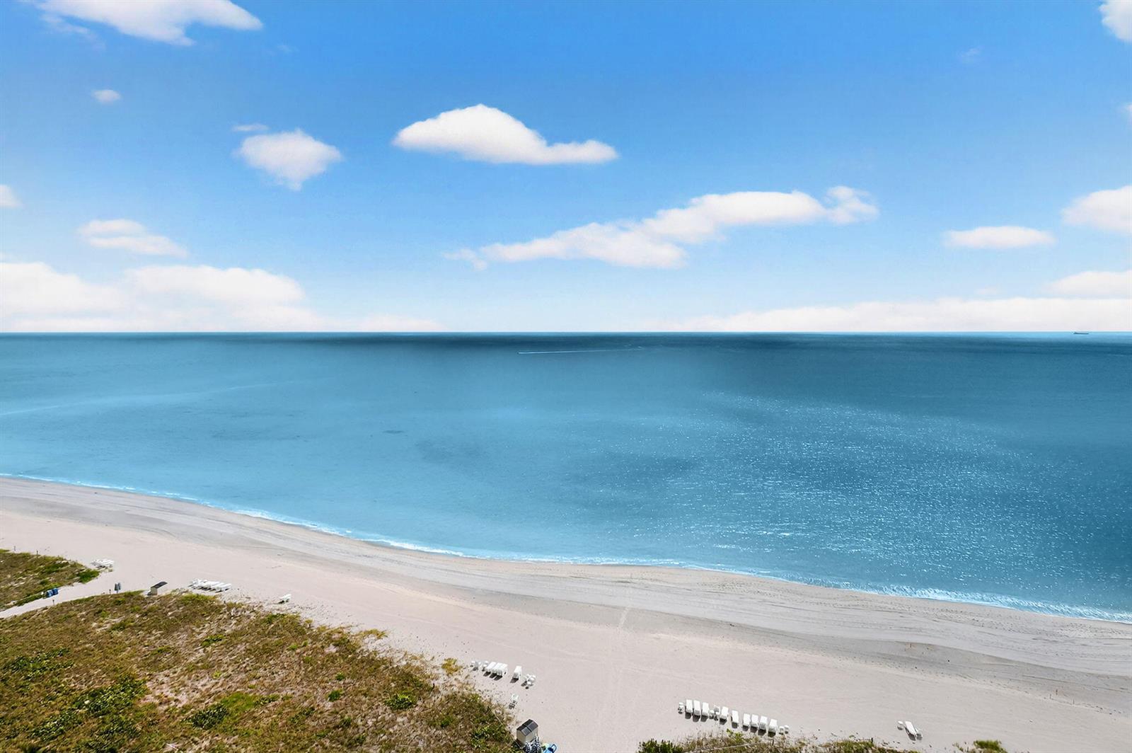 An aerial view of a sandy beach meeting the blue ocean under a cloudy sky — 1500 S Ocean Boulevard, Boca Raton FL 33432, BOCA RATON, FL