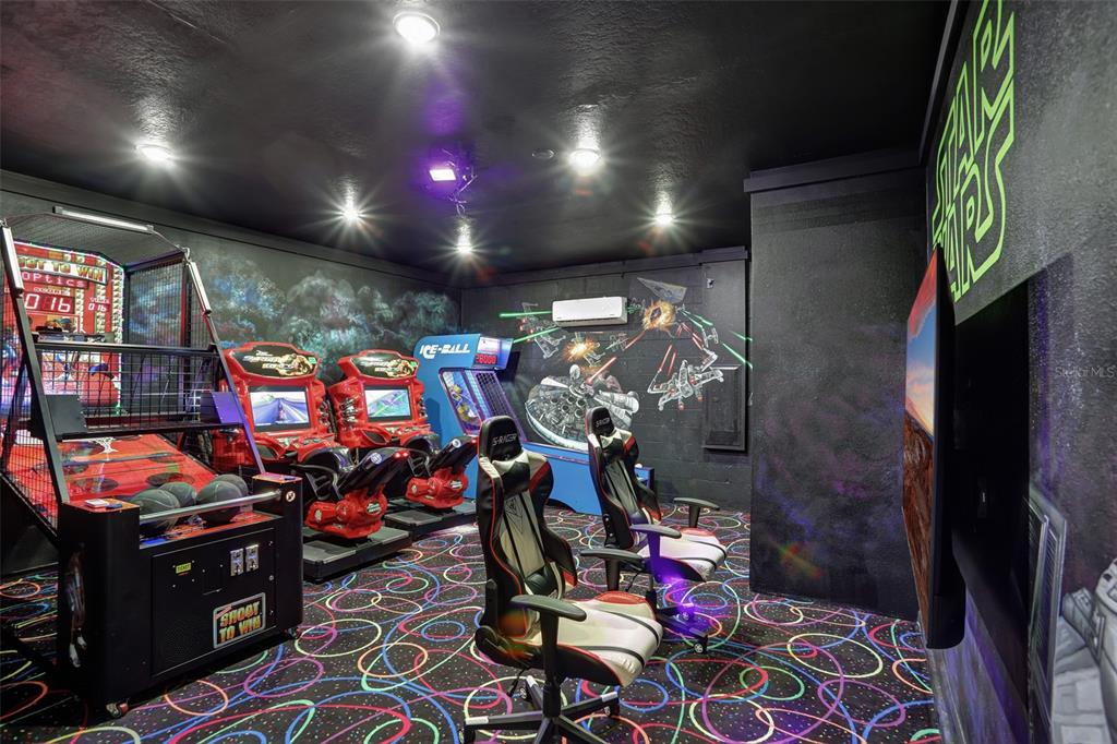 A Star Wars-themed game room features arcade machines, gaming chairs, and a neon wall sign — 1533 FLANGE DRIVE, DAVENPORT, FL