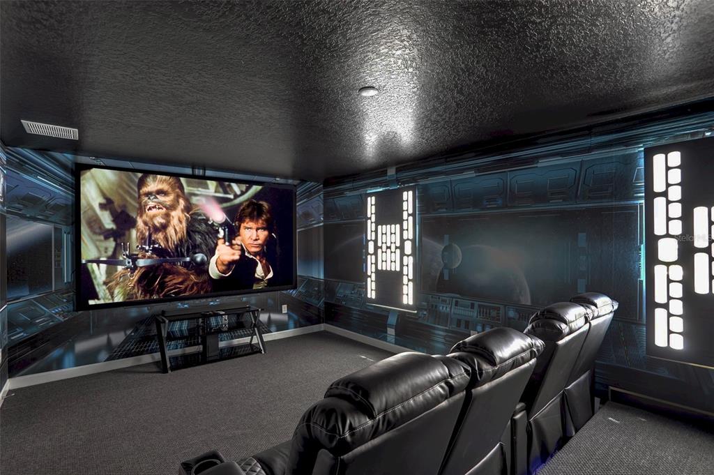 A Star Wars-themed home theater features a large projection screen, black leather seating, and wallpaper — 1533 FLANGE DRIVE, DAVENPORT, FL