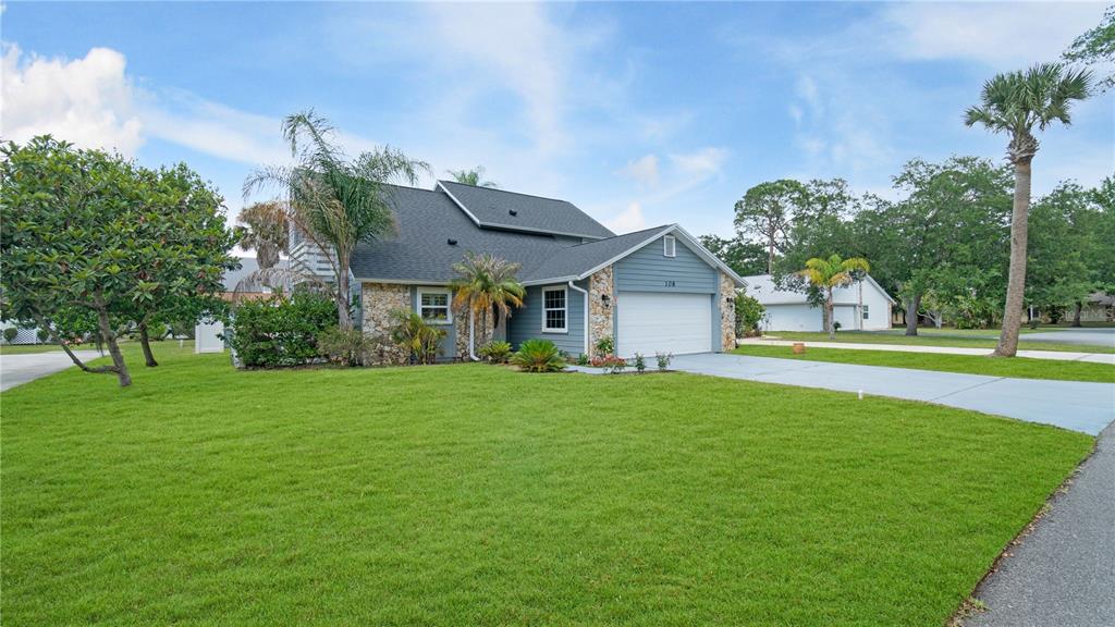 A two-story house with a stone facade, blue siding, and a two-car garage — 108 GREBE COURT, DAYTONA BEACH, FL