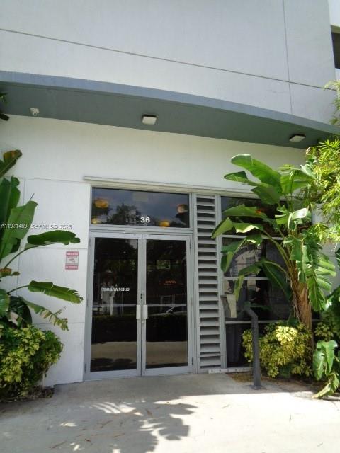 The exterior entrance features double glass doors under a gray overhang with a building number — 36 NW 6 Ave # 608, Miami FL 33128, MIAMI, FL