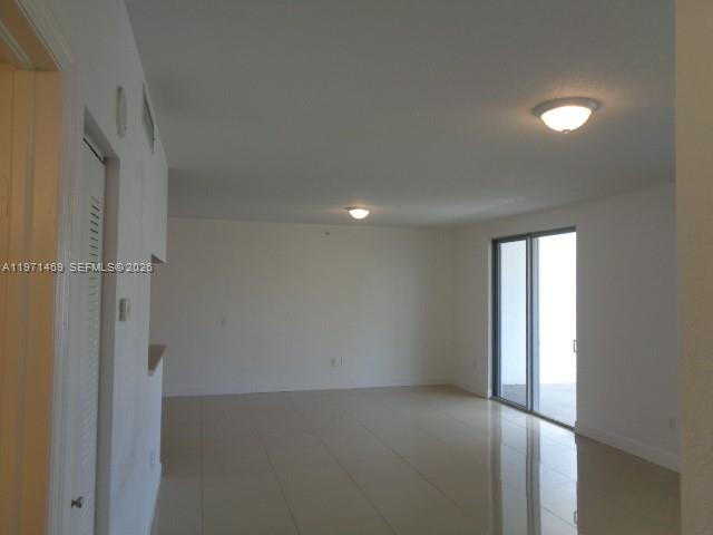 An empty room with white walls, tile flooring, two ceiling lights, and a sliding door — 36 NW 6 Ave # 608, Miami FL 33128, MIAMI, FL