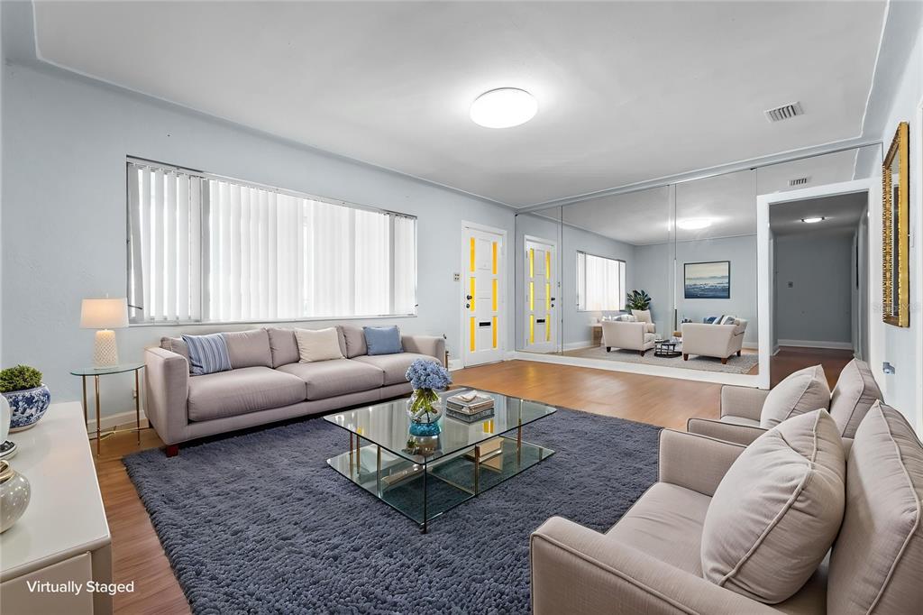 A living room features a grey sofa, a glass coffee table, and a mirrored wall — 2505 E 19TH AVENUE, TAMPA, FL