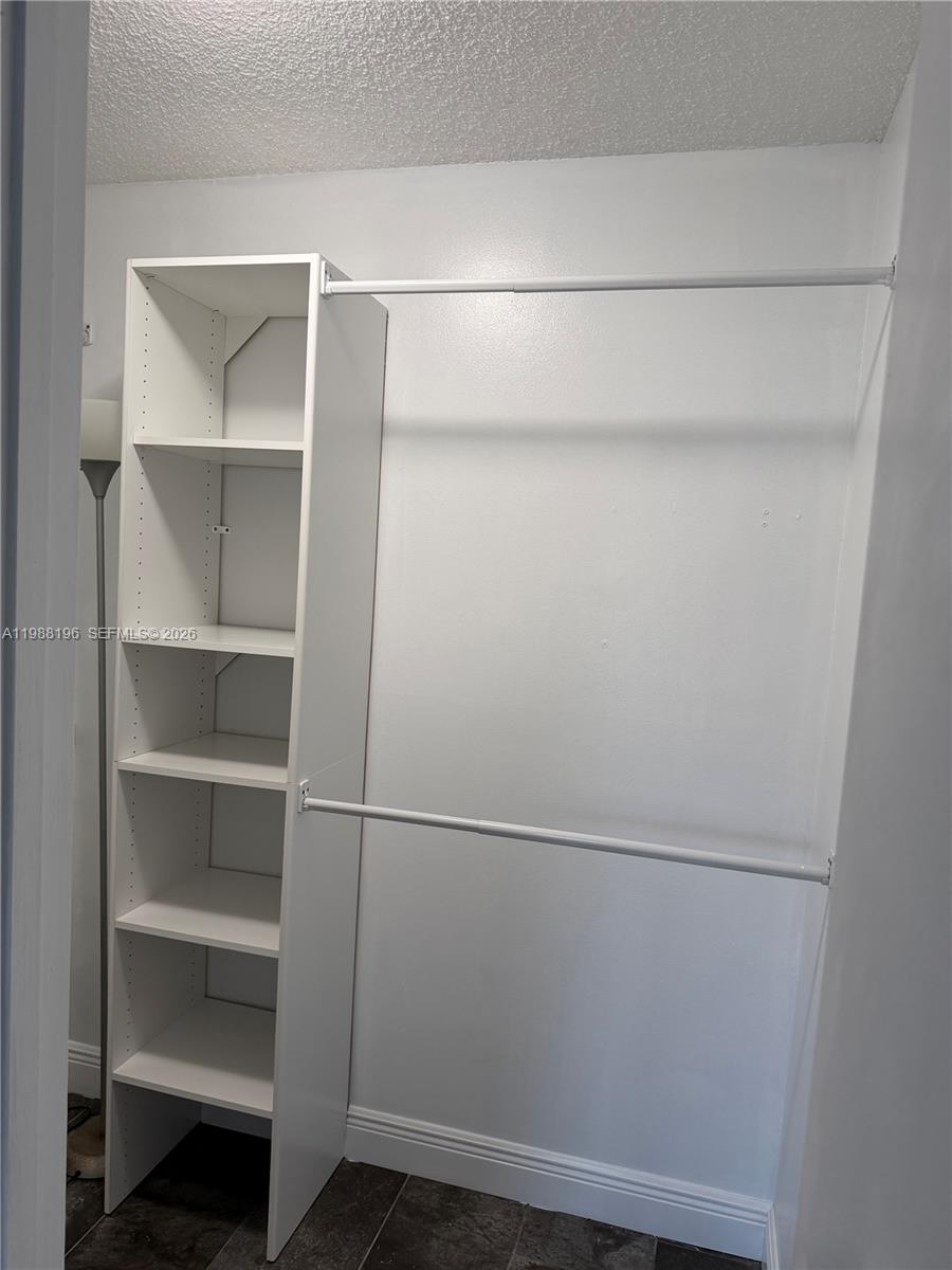 A closet features a white shelving unit and two adjustable metal clothing rods — 9355 SW 8th St # 305, Boca Raton FL 33428, BOCA RATON, FL