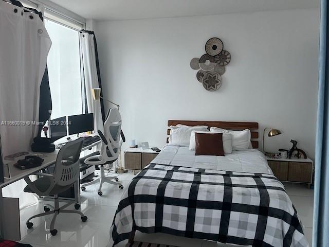 A bedroom features a bed with a plaid comforter, a desk, and wall-mounted decorative baskets — 1040 Biscayne Blvd # 2607, Miami FL 33132, MIAMI, FL