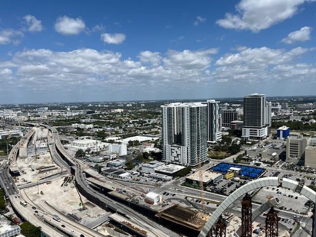 An elevated view shows a highway interchange, modern high-rise buildings, and a city skyline — 1040 Biscayne Blvd # 2607, Miami FL 33132, MIAMI, FL