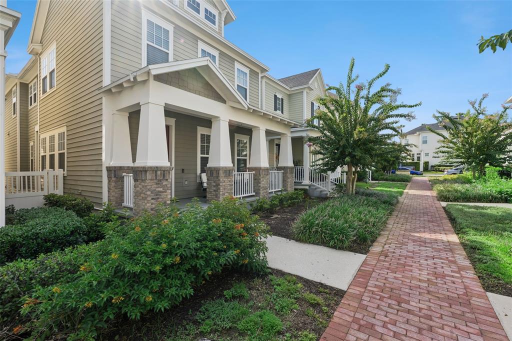 A two-story house with a covered front porch, stone columns, and a brick walkway — 1425 RESOLUTE STREET, CELEBRATION, FL