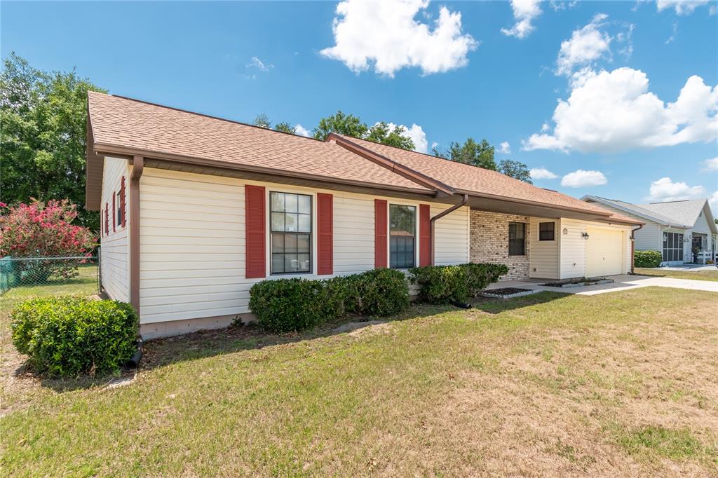 A single-story house with beige siding, red shutters, and a brick accent wall — 3340 NW 44TH COURT, OCALA, FL