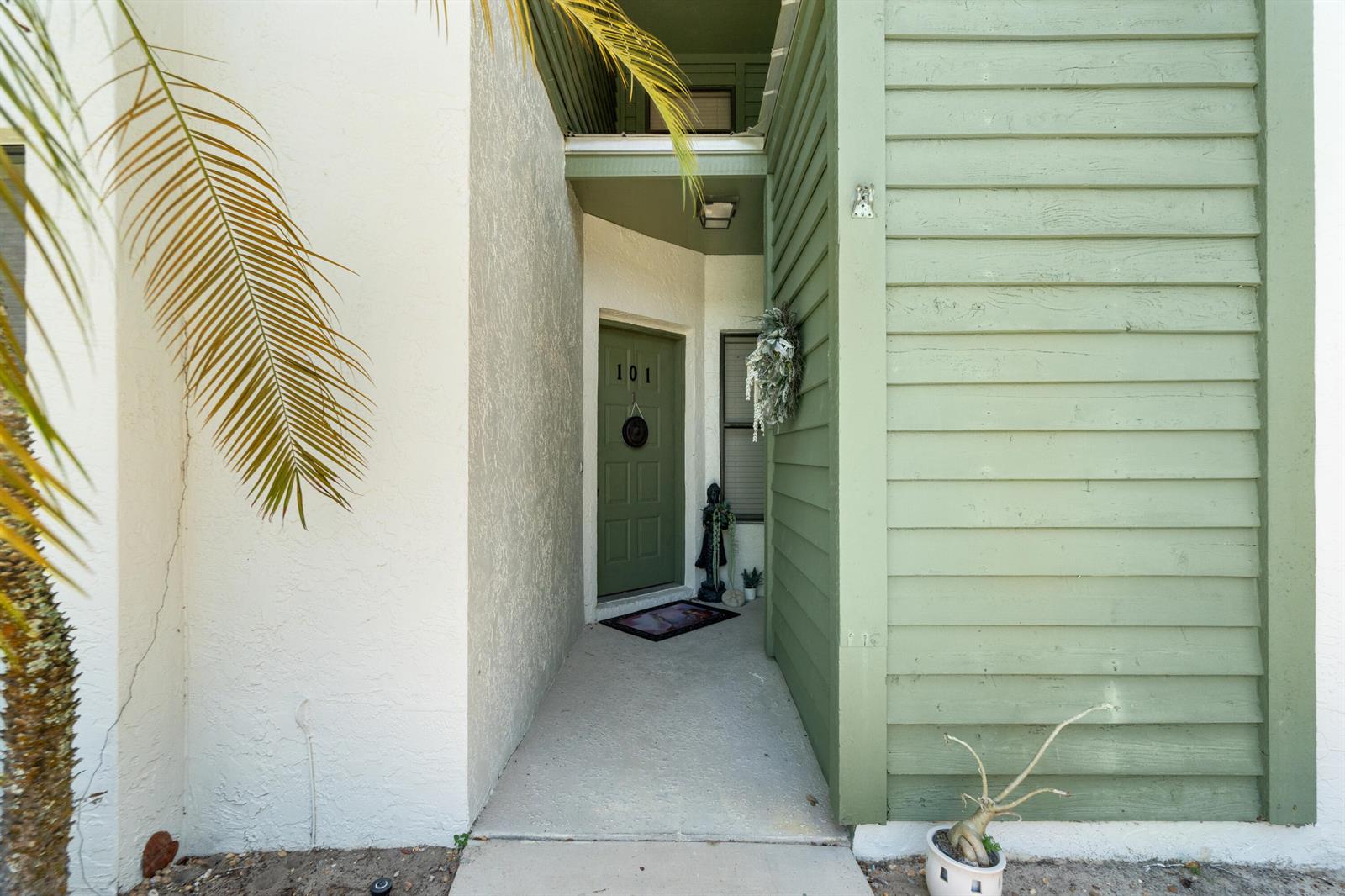 The exterior entrance to a residential unit features a green door numbered 101 — 5280 SE Seascape Way # 101, Stuart FL 34997, STUART, FL
