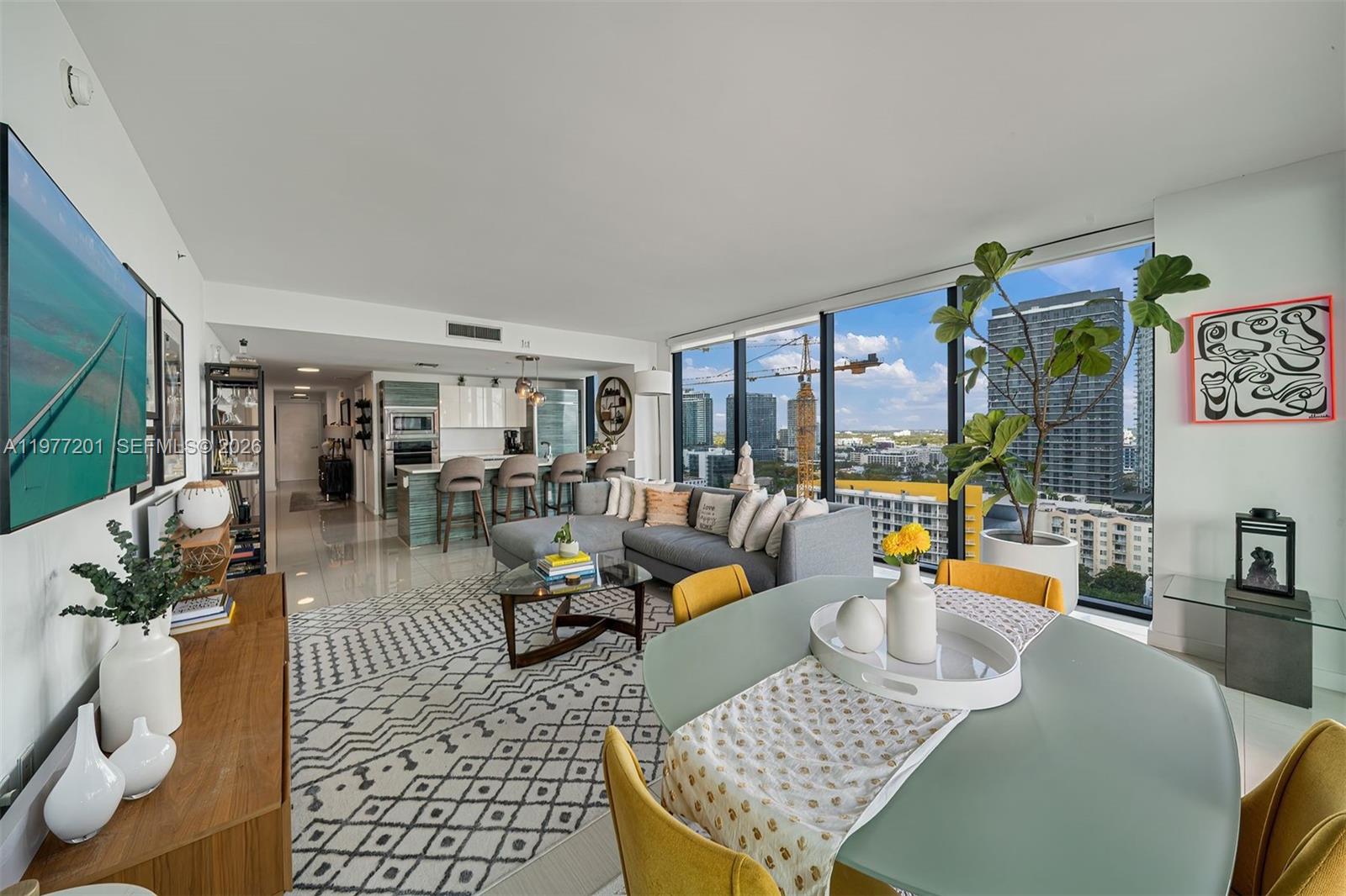 A modern living and dining area with floor-to-ceiling windows overlooking a city skyline — 460 NE 28th St # 1901, Miami FL 33137, MIAMI, FL