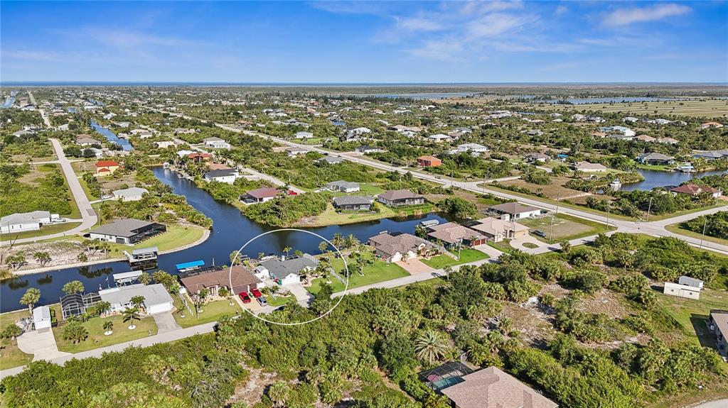 An aerial view shows a residential neighborhood with houses situated along a canal — 10264 WINNIPEG STREET, PORT CHARLOTTE, FL