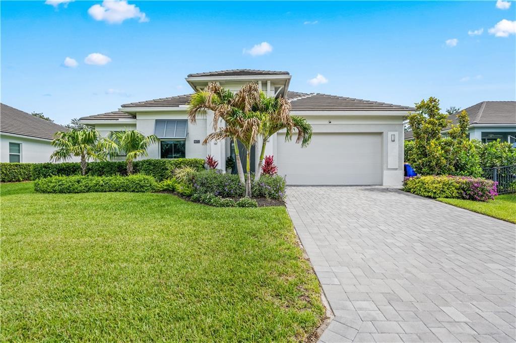 A single-story house with a paved driveway, a two-car garage, and landscaped front yard — VERO BEACH, FL