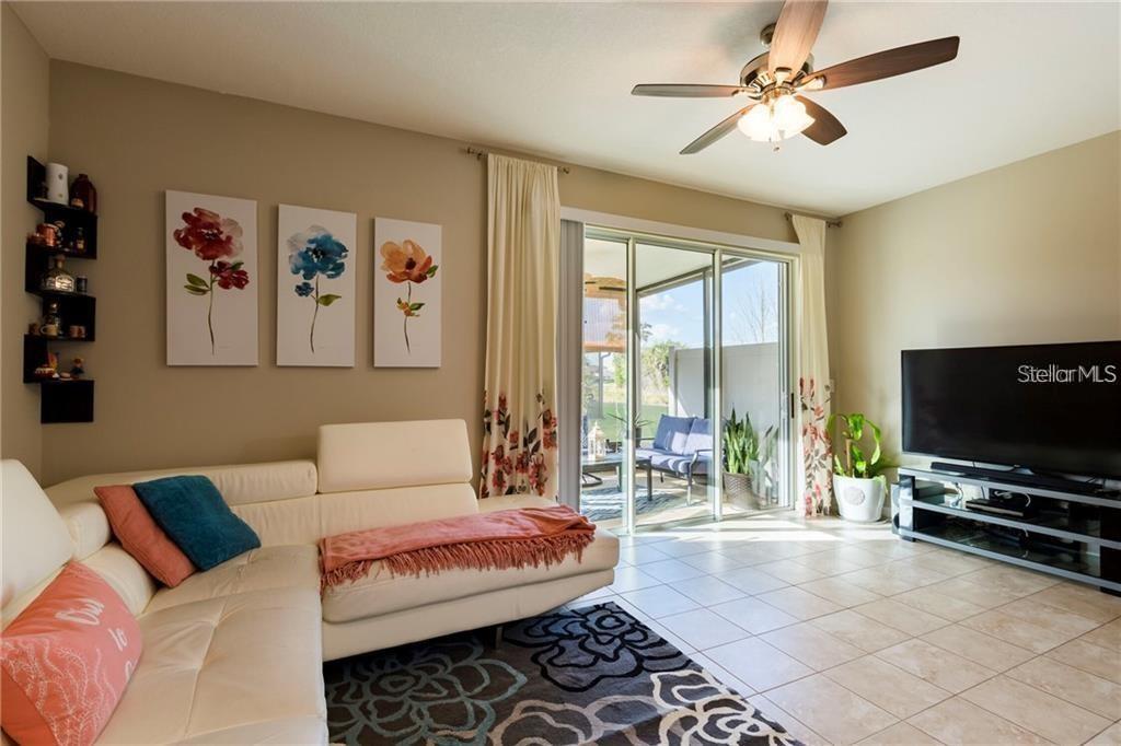 A living room features a white sectional sofa, a patterned rug, and a sliding glass door — 6959 TOWNE LAKE ROAD, RIVERVIEW, FL