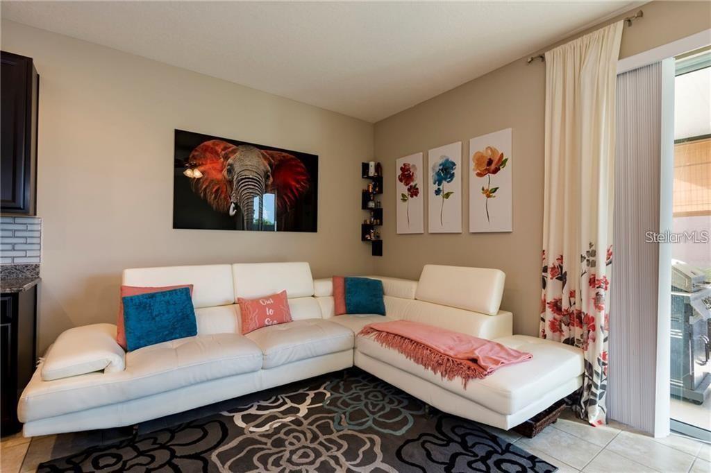 A living room features a white sectional sofa, a floral rug, and wall art — 6959 TOWNE LAKE ROAD, RIVERVIEW, FL