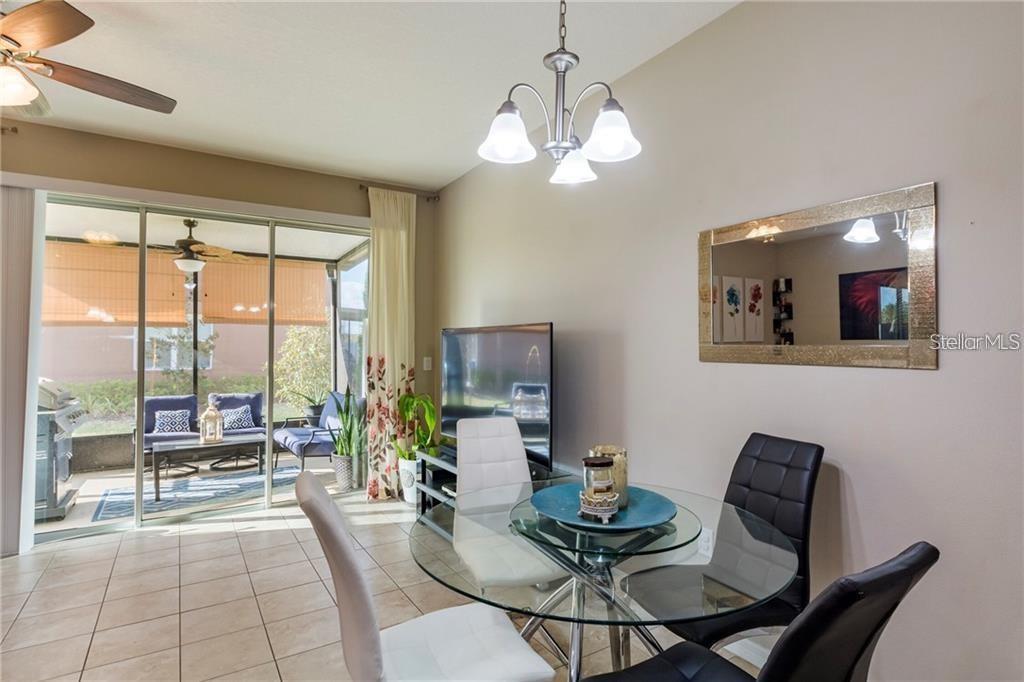 A dining area with a glass table, four chairs, and a sliding door to a patio — 6959 TOWNE LAKE ROAD, RIVERVIEW, FL
