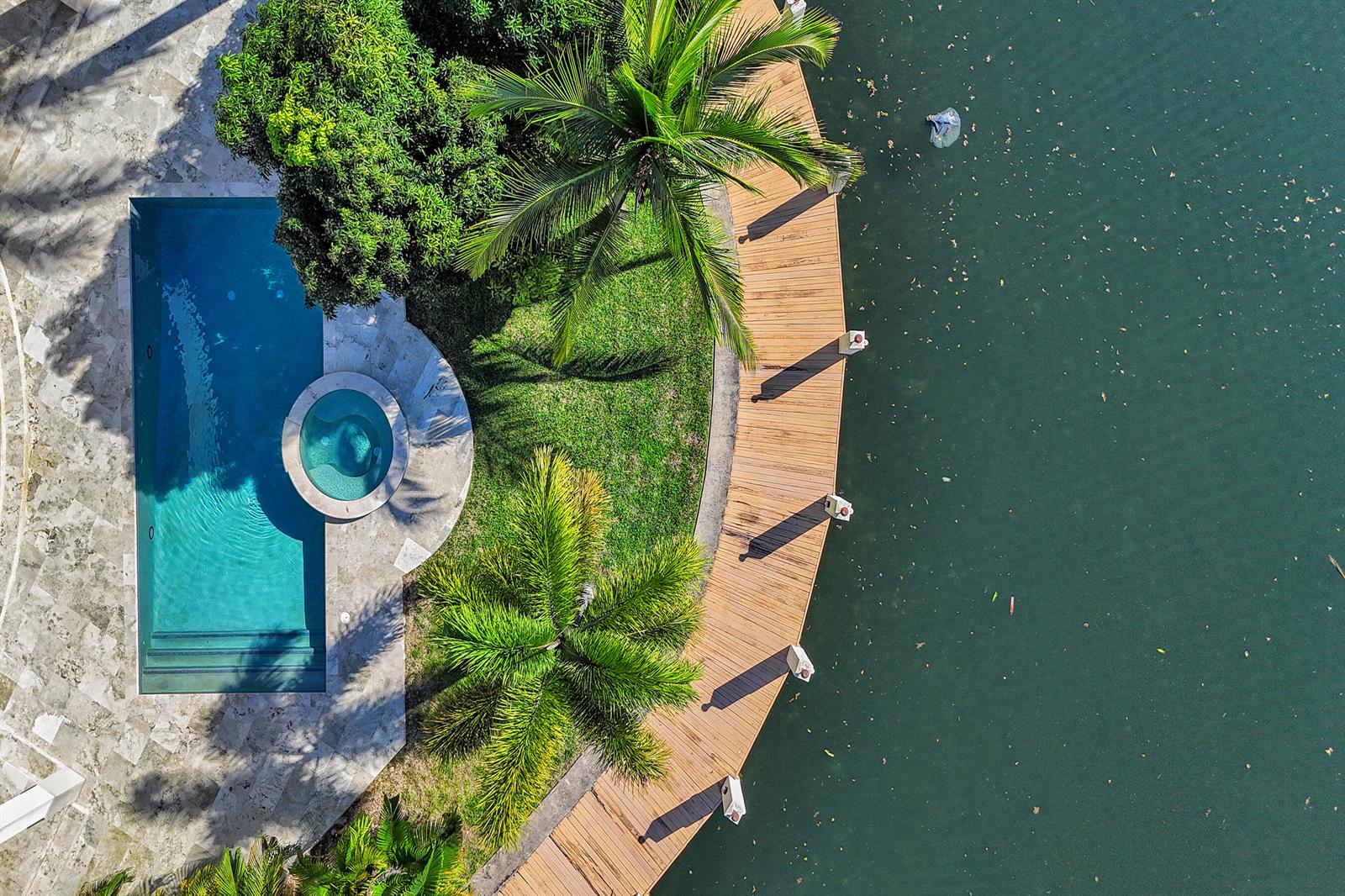 An aerial view shows a swimming pool, hot tub, palm trees, and a curved wooden dock — 2330 NE 31st Court, Lighthouse Point FL 33064, LIGHTHOUSE POINT, FL