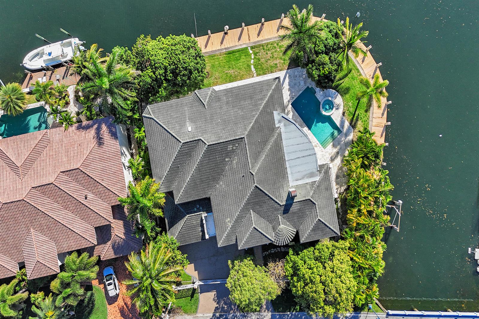 An aerial view shows a waterfront house with a tiled roof, pool, and private dock — 2330 NE 31st Court, Lighthouse Point FL 33064, LIGHTHOUSE POINT, FL