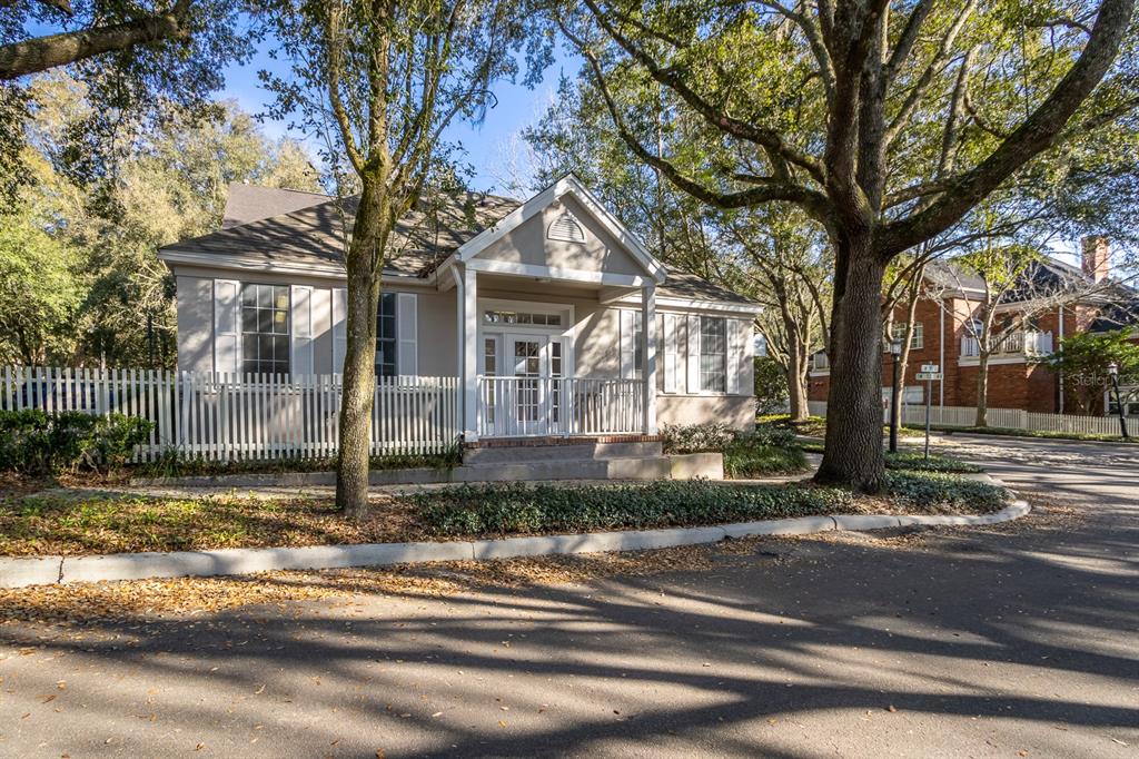 A single-story building with a white picket fence and a covered porch under large trees — 5213 & 5217 & 5231 SW 91ST DRIVE, GAINESVILLE, FL